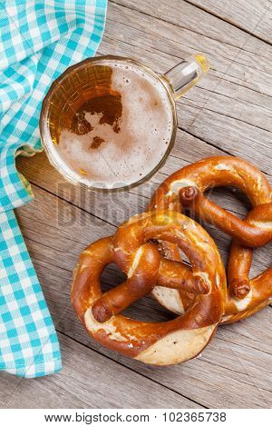Beer mug and pretzel on wooden table. Top view