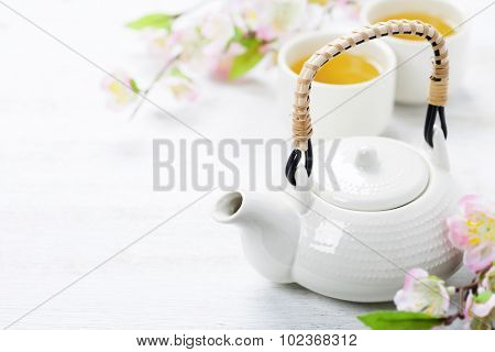 Chinese Tea Set  and sakura branch on bamboo mat