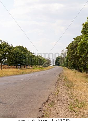 Old Damaged Asphalt Road In Rural Ukraine. Rural Landscape.