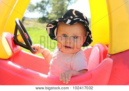 Beautiful Baby Playing Outside In Toy Car