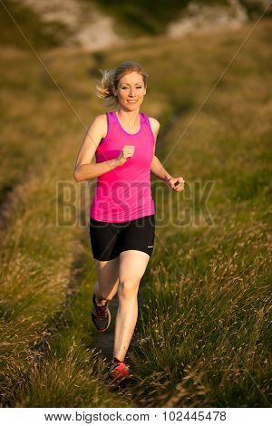 Beautiful Young Woman Runns Cross Country On A Mountian Path At Sunrise