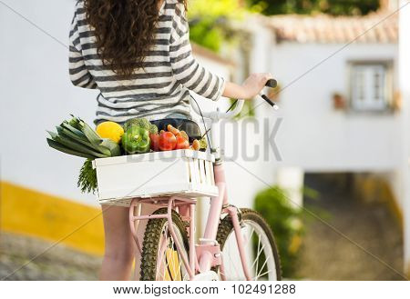 Beautiful female tourist living like a local, with her bicycle after buying some fresh vegetables