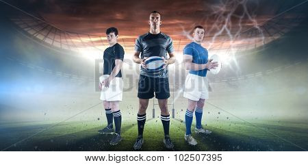 Rugby player holding rugby ball against rugby pitch