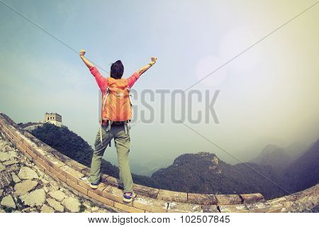 cheering woman hiker open arms on chinese great wall