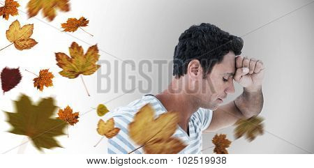 Upset man leaning on white background against autumn leaves