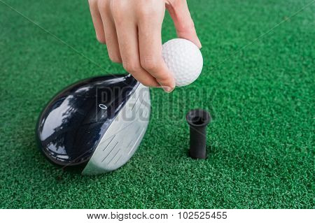 Close-up Hand Holding Golf Ball And A Golf Wood On A Driving Range