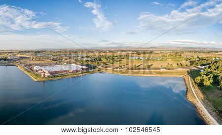 aerial panorama of northern Colorado with a shopping mall, freeway, bike trail and numerous ponds and reservoirs with Front Range of Rocky Mountains ion a horizon
