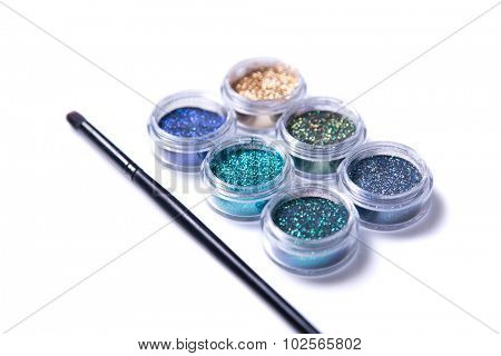 Set of sparkling glitters in jars, selective focus, isolated on white background 