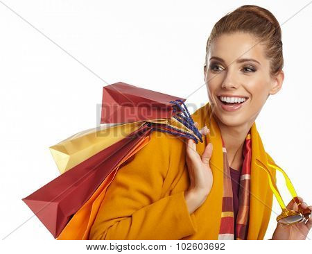 Woman wearing autumn overcoat holding shopping bag.