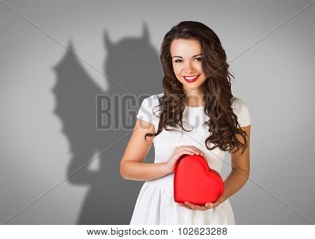 Businesswoman stands with shadow on the wall