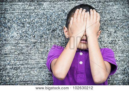 Young Asian boy using his hand to protect himself from physical abuse