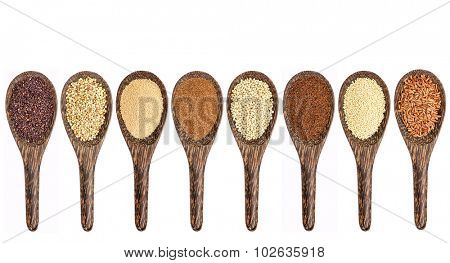 a variety of gluten free grains (from left: black quinoa, buckwheat, amaranth, teff, sorghum, kaniwa, millet, and brown rice) - set of wooden spoons isolated on white