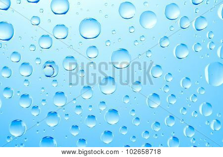 background of blue water big and small drops on glass with gradient