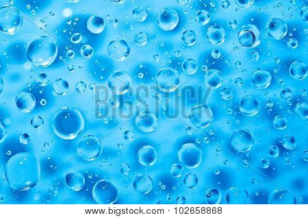 background of blue water big and small drops on glass