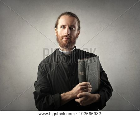 Priest holding a Bible