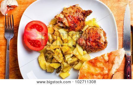 Plate Of Chicken And Potatoes Baked On A Grill