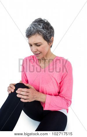 Mature woman suffering from knee pain over white bckground
