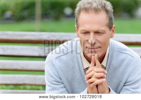 Pleasant man sitting on the bench