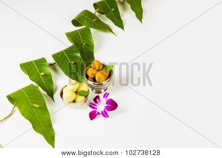 arland of mango leaves with indian sweet pedha and orchid flower . It is auspicious in hindu religio