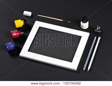Template With White Photo Frame On Pink Paper With Brushes And Gouache And Pencils. Painter Workplac