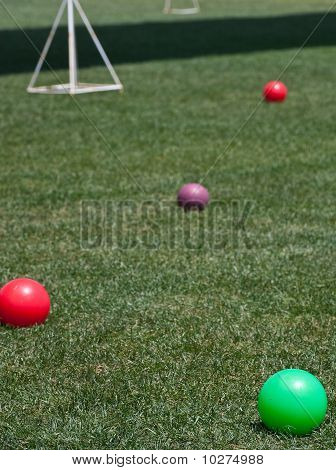 Neljä värillistä Bocce palloa, vihreä nurmikko