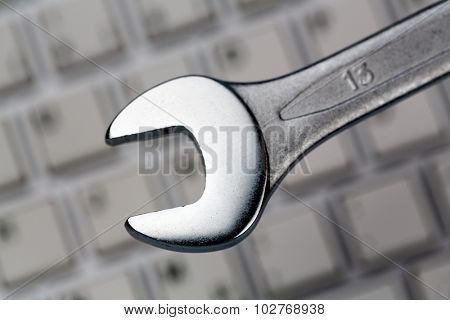 a wrench as a tool on a computer keyboard. symbolic photo for data protection, online crime, and security on the internet