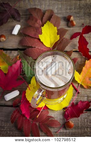 Cocoa With Marshmallow On The Background Of Bright Autumn Leaves