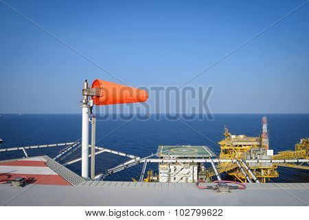 The wind sock is set on the oil rig to showing wind direction for helicopter landing .