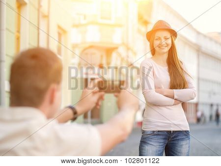 Touristic couple shooting on the modile phone at the city streets under sunlight.