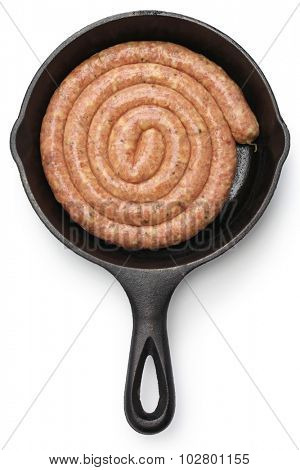 raw cumberland sausage, spiral pork sausage on skillet isolated on white background