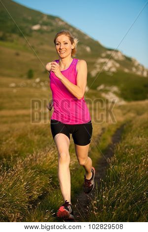 Beautiful Young Woman Runns Cross Country On A Mountian Path At Sunrise