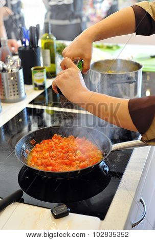 Chef prepares tomatoes to Italian minestrone soup