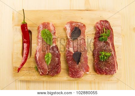 Fresh Raw Pork On Cutting Board With Spices And Herbs