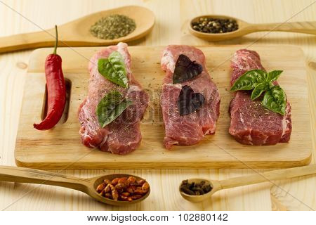 Fresh Raw Pork On Cutting Board With Spices And Herbs