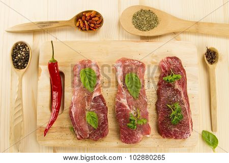 Fresh Raw Pork On Cutting Board With Spices And Herbs