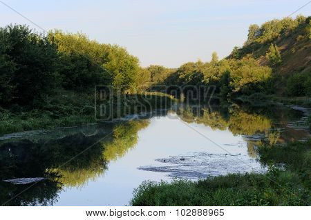Quiet Small River With Green Trees On Both Banks In Early Summer Morning
