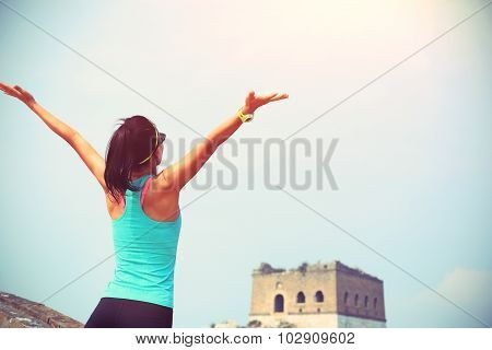 cheering woman hiker open arms on chinese great wall