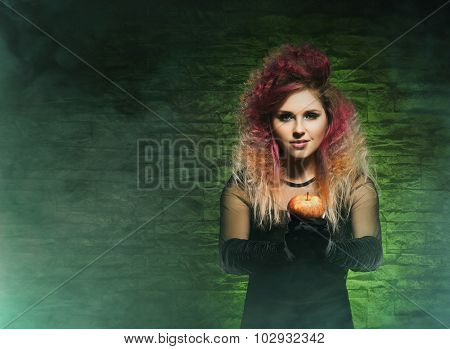 Beautiful witch giving an intoxicate apple. Halloween concept.
