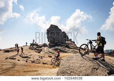 Unidentified biker climbs the hill in Bucegi Mountains in Romania