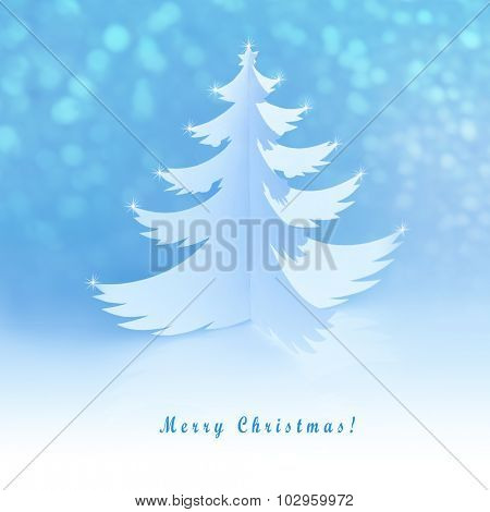 White handmade paper cut christmas tree with magic defocused snowflakes