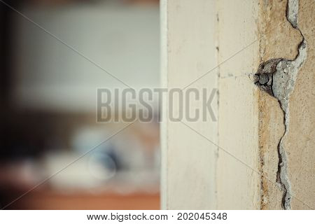 A cracked wall closeup a house needs renovation. Filtered photo