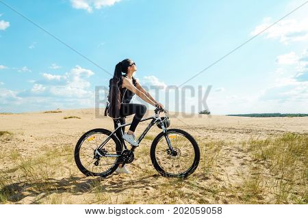 Woman Cyclist Carrying Mountain Bike On Sunrise Trail. Girl In Sport Wear On Black White Bicycle Goi