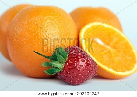 four oranges and strawberrie on white background.