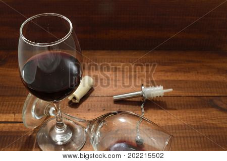 Glass of red wine and take out corks on brown wooden background