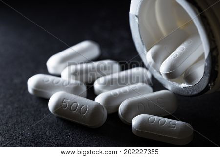 Paracetamol medicine tablets on dark background in low key tone