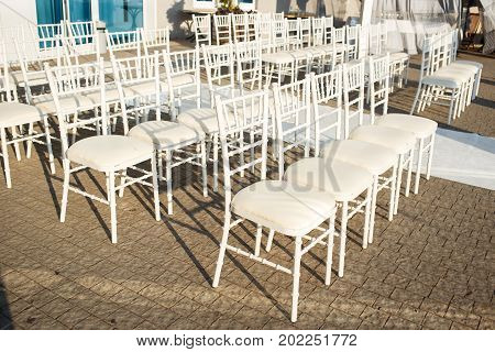 White Chiavari chairs for wedding guests at the ceremony