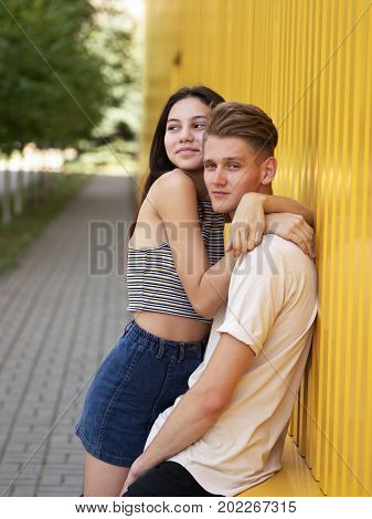 A portrait of an attractive boy and wonderful girl are posing and hugging on a background of a colorful nature. A loving young couple has beautiful moments of happiness and joy in the outdoors.