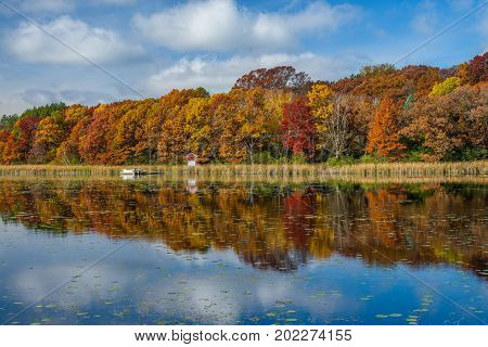a calm windless autumn day reflects a variety of colors on east boot lake washington county minnesota.