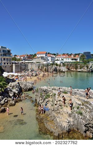 CASCAIS PORTUGAL - JUNE 07 2017: People relaxing on the Praia da Rainha public beach. Cascais is famous and popular summer vacation spot for Portuguese and foreign tourists