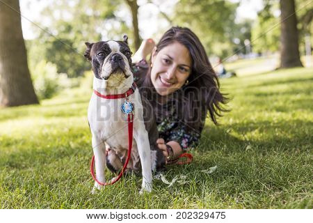 A woman with terrier dog outside at the park